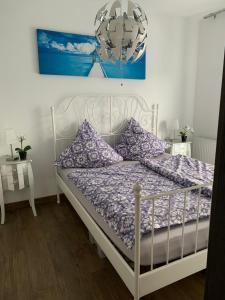 ジブヌフにあるIve's Golden Gardenia Seasideのベッドルーム(紫色の枕が付いた白いベッド付)