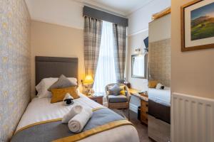 a bedroom with a bed and a chair in a room at Avondale Guest House in Keswick