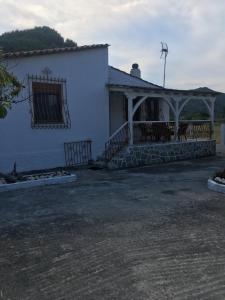 uma casa branca com um alpendre e um telhado em Andronikis House em Sikia