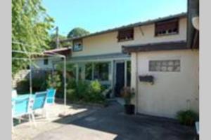 a house with two blue chairs in front of it at La Providence in Chaumont