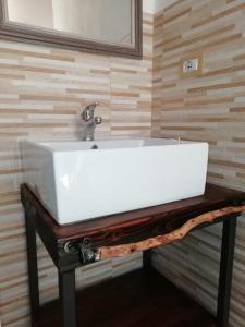 lavabo blanco en una mesa de madera en el baño en Beni Benìus, en Teulada