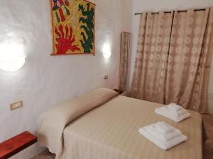 a bedroom with a bed with two towels on it at Beni Benìus in Teulada