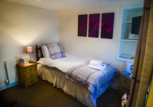 um pequeno quarto com uma cama e uma mesa de cabeceira com uma cama sidx sidx em THE Waterloo Arms Hotel em Chirnside
