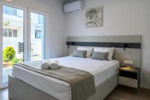a bedroom with a large bed with two towels on it at Makrygialos Long Beach Villa 1 in Makry Gialos