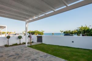 a backyard with a white fence and a lawn at Makrygialos Long Beach Villa 1 in Makry Gialos
