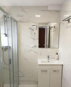 a bathroom with a shower and a sink and a mirror at Babylon Tourist Apartments in Benalmádena