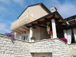 ein Haus mit Blumen an einer Steinmauer in der Unterkunft Danijela Rovinj sea view and free parking in Rovinj