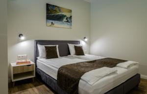a bedroom with a large bed with a night stand at Rusnės Perlo apartamentai in Rusnė