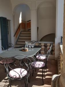 einen Tisch und Stühle mit Weingläsern und eine Treppe in der Unterkunft Villa Maghetti - modernized flat in historic palazzo in the center of Luino in Luino