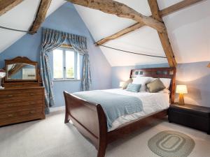 a bedroom with a bed and a dresser and a window at Woodcock Farm in Bristol