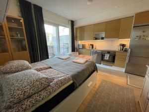 a bedroom with a large bed and a kitchen at The Seaside Apartment in Turku