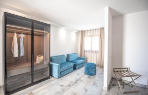 ein Wohnzimmer mit einem blauen Sofa und einem Stuhl in der Unterkunft Ciuri Di Mari in San Vito lo Capo