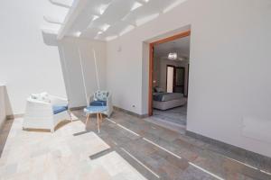 ein Wohnzimmer mit weißen Wänden und einem blauen Stuhl in der Unterkunft Ciuri Di Mari in San Vito lo Capo