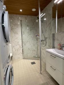 a bathroom with a shower and a sink at The Seaside Apartment Turku in Turku