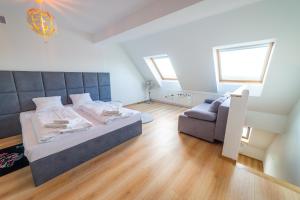 um quarto com uma cama grande e um sofá em Apartamenty BOJAR em Mikolajki