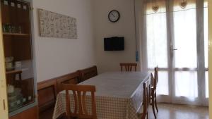 una sala da pranzo con tavolo e orologio sul muro di Ortensie a Tirrenia