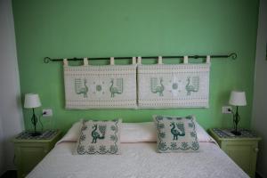 een slaapkamer met een bed met kussens erop bij S'Arena Dorada Deluxe Apartment in Alghero
