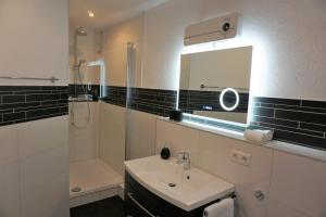 a bathroom with a sink and a shower and a mirror at Hotel Jan van Werth in Koblenz