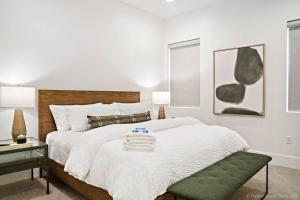 a white bedroom with a large bed with a green ottoman at Villa #24 at Bloomington Country Club in St. George