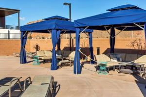 a patio with blue umbrellas and tables and chairs at Villa #24 at Bloomington Country Club in St. George