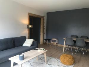 a living room with a blue couch and a table at Appartement centre Barcelonnette in Barcelonnette