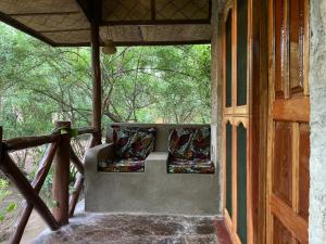 a porch of a house with two pillows on it at Camp Bastian Mikumi in Mikumi