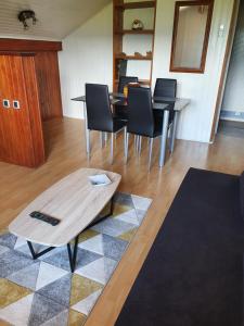 ein Wohnzimmer mit einem Tisch und schwarzen Stühlen in der Unterkunft Chez Gilles et Eveline in Cruet