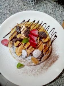 a dessert on a white plate on a table at Techas City Center Luxurious Suite in Praia