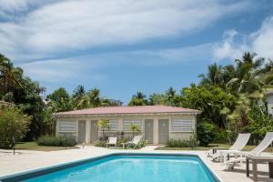 a villa with a swimming pool and a house at Hôtel Les Bananiers in Le Gosier