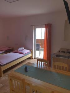 a bedroom with a bed and a table and a window at Penzion U Pavla in Most