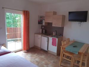 a room with a kitchen and a table and a bed at Penzion U Pavla in Most