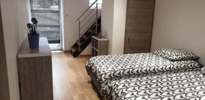 1 dormitorio con 2 camas y escalera en JAB'S HOME, en Colmar