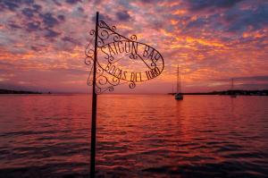 a sign in the middle of the water with a sunset at Saigon Bay Bed & Breakfast in Bocas Town