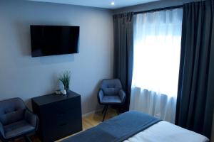 a bedroom with a bed and a tv and two chairs at Ferienhaus Steins in Sinspelt