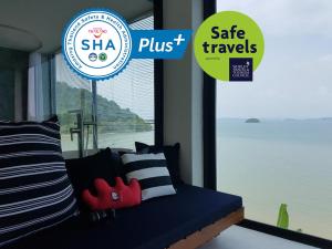 波灣的住宿－8IK88 Resort - SHA Extra Plus，蓝色的沙发,带有枕头,还有一个标有安全旅行的标志