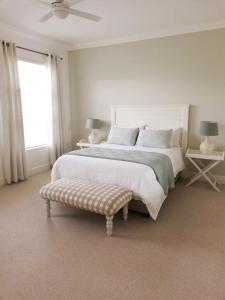 a white bedroom with a large bed and a window at A home for the ultimate West Coast beach holiday in St Helena Bay