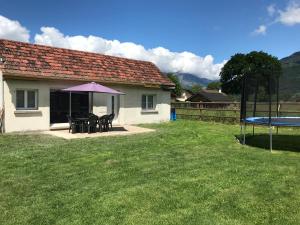 een huis met een picknicktafel en een trampoline in een tuin bij maisonnette entre lac de Passy et montagnes in Domancy