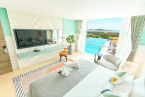een hotelkamer met een groot bed en een televisie bij Hilltop Wellness Resort in Phuket