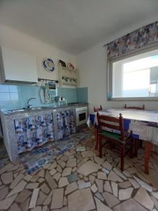 eine Küche mit einem Tisch, einer Spüle und einer Theke in der Unterkunft GIADA MARIA SOLE HOUSE in Pulsano