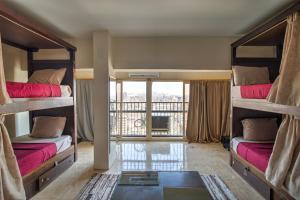 two bunk beds in a room with a balcony at Castle Hostel in Cairo
