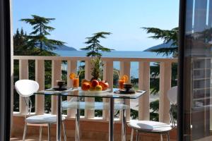a table with a bowl of fruit on a balcony at Montesun Residence in Herceg-Novi