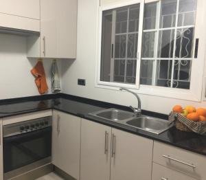 a kitchen with a sink and a window at Torredembarra House in Torredembarra
