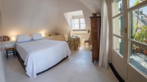 ein Schlafzimmer mit einem weißen Bett und einem Fenster in der Unterkunft Attico Palazzo Giustiniani in Genua