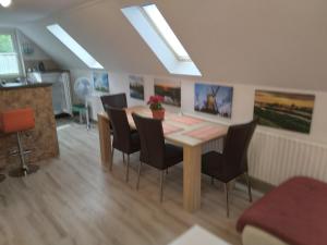 a dining room with a wooden table and chairs at Raza Soarelui apartament de lux in Sovata