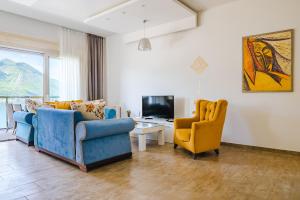 a living room with two chairs and a television at Apartments Casa Delone in Kotor