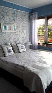 a bedroom with a large bed and a window at Katarina Beach Apartments in Puck