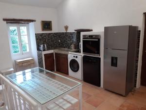 a kitchen with a refrigerator and a washer and dryer at La vagolo in Luri