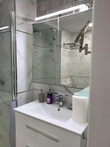 een witte badkamer met een wastafel en een spiegel bij SALESAS OVIEDO CENTRO COMERCIAL CORTE NGLES- Apartamento in Oviedo