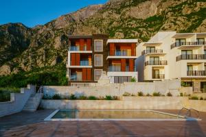 a building with a mountain in the background at Apartments Casa Delone in Kotor