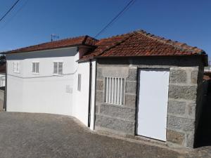 a small white garage with two white doors at Santo Tirso Holidays Home in Santo Tirso